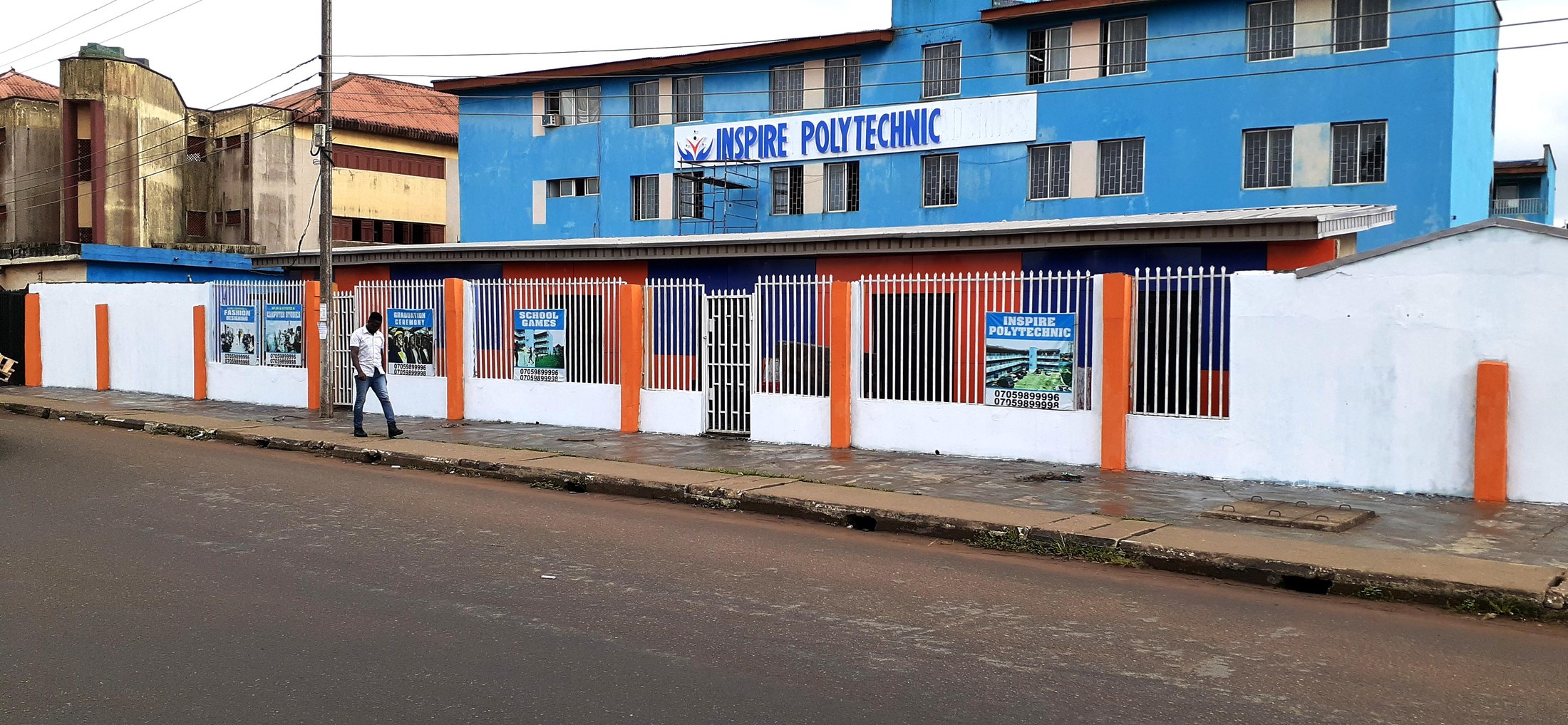 The blue and orange Inspire Polytechnic street frontage with its institutional sign.