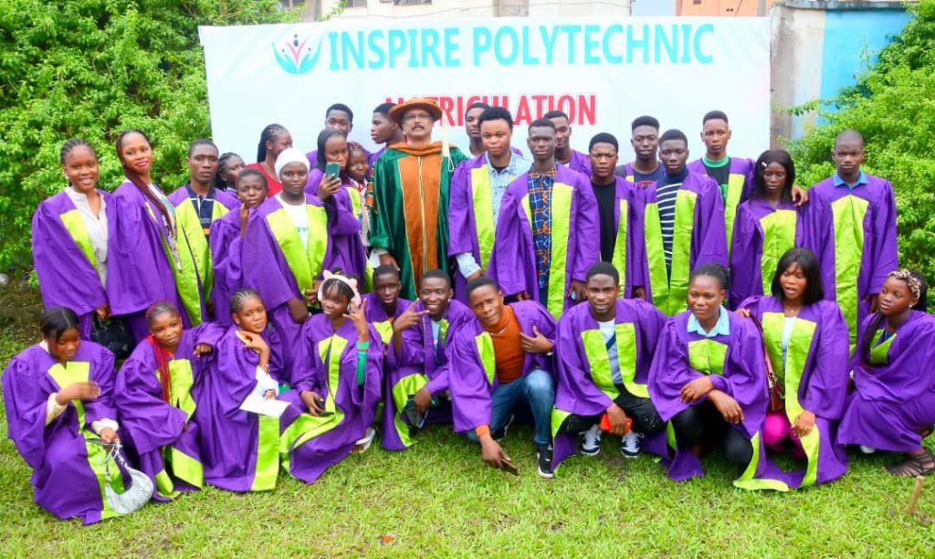 Participants in academic gowns pose for a group photograph at an Inspire matriculation event.