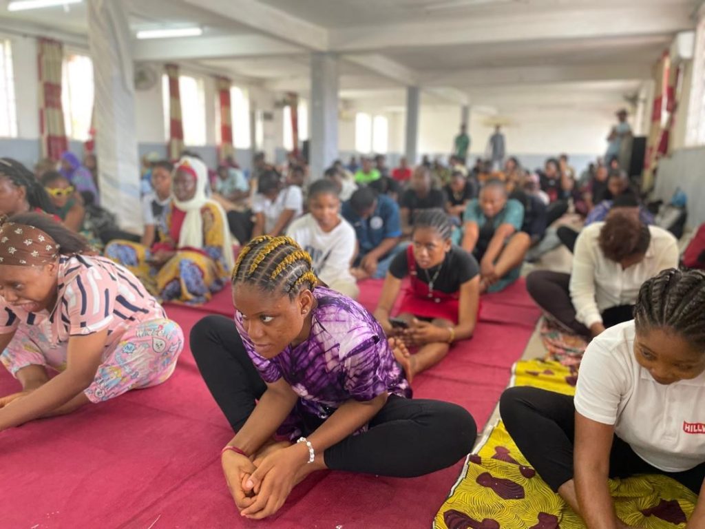 Participants sit on mats and stretch during a group activity.